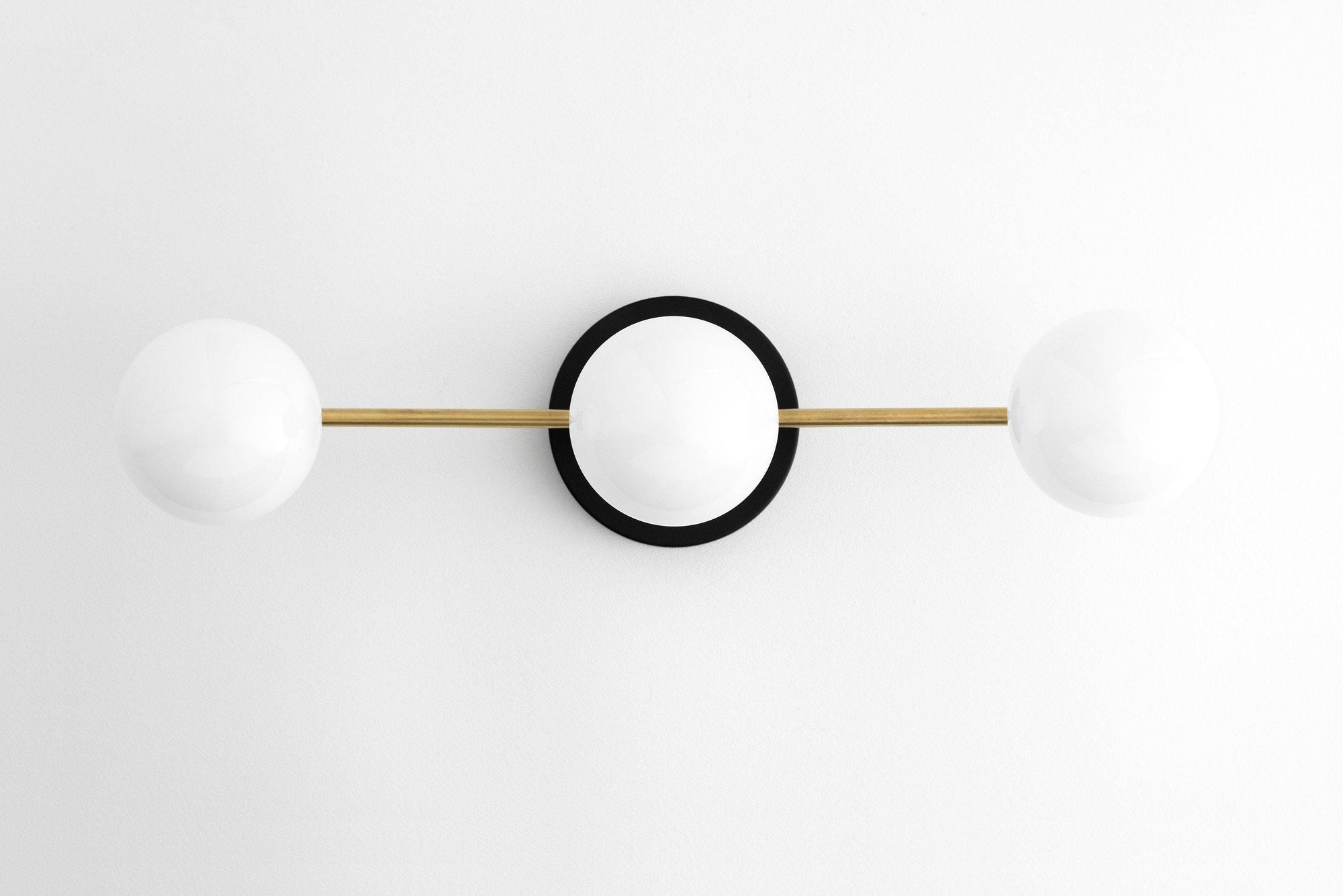 Mid-century modern vanity light with two white glass globes and raw brass rod on black circular base. - VANITY LIGHT MODEL NO. 0518