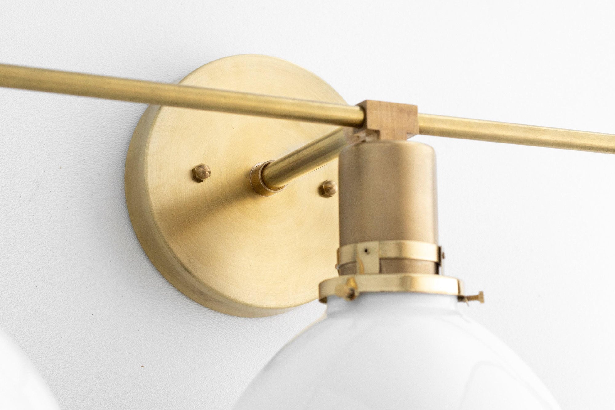 Mid-century modern raw brass vanity light with round wall mount and white globe shade. - VANITY LIGHT MODEL NO. 2439