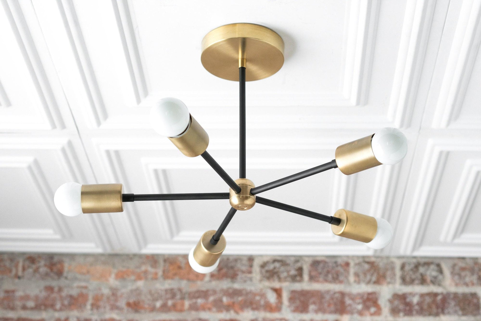 Mid-century modern chandelier with seven black arms and raw brass cylindrical light sockets with white globe bulbs. - CHANDELIER MODEL NO. 6652