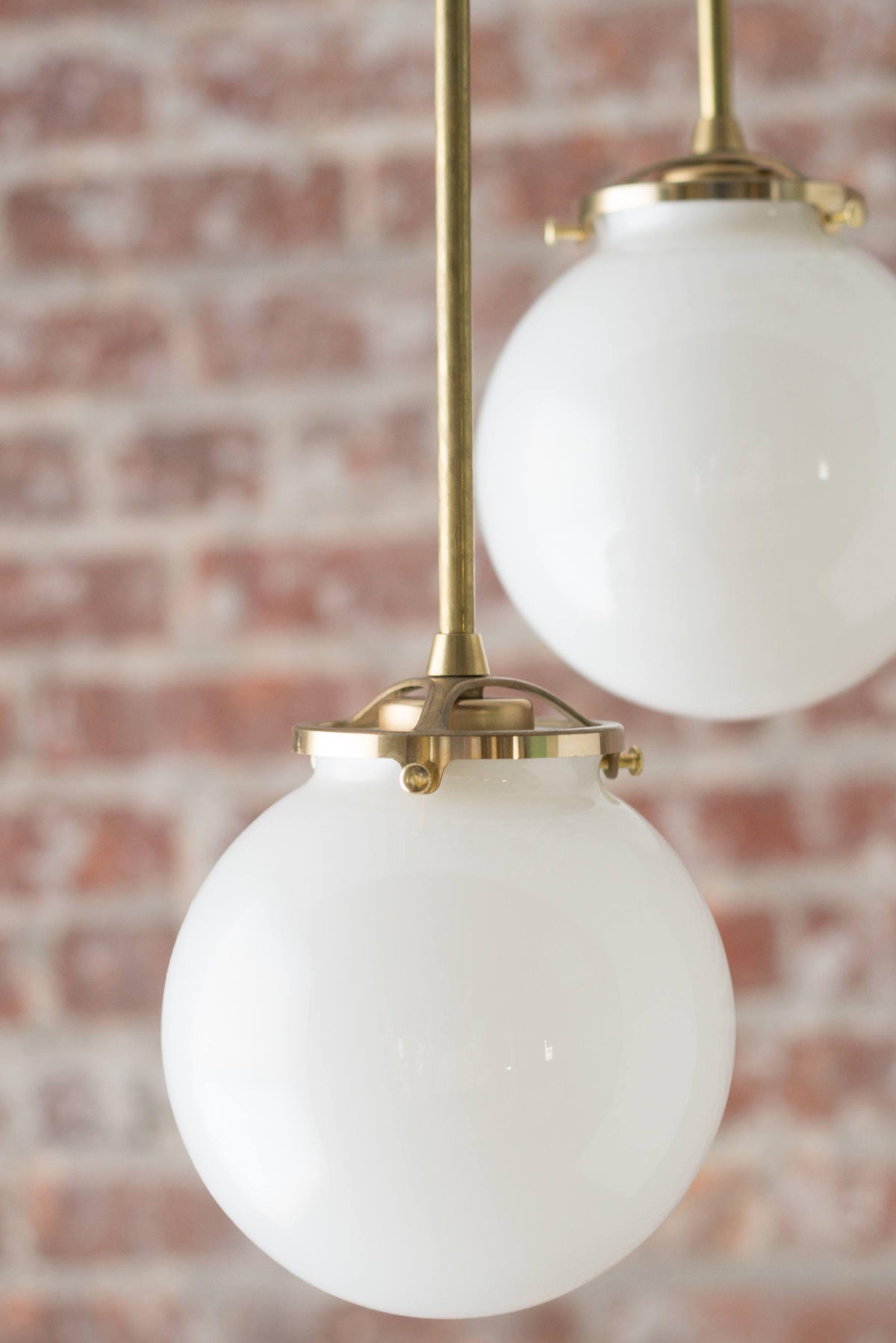 Mid-century modern chandelier with raw brass finish and two white glass globe shades suspended on rods. - CHANDELIER MODEL NO. 1809