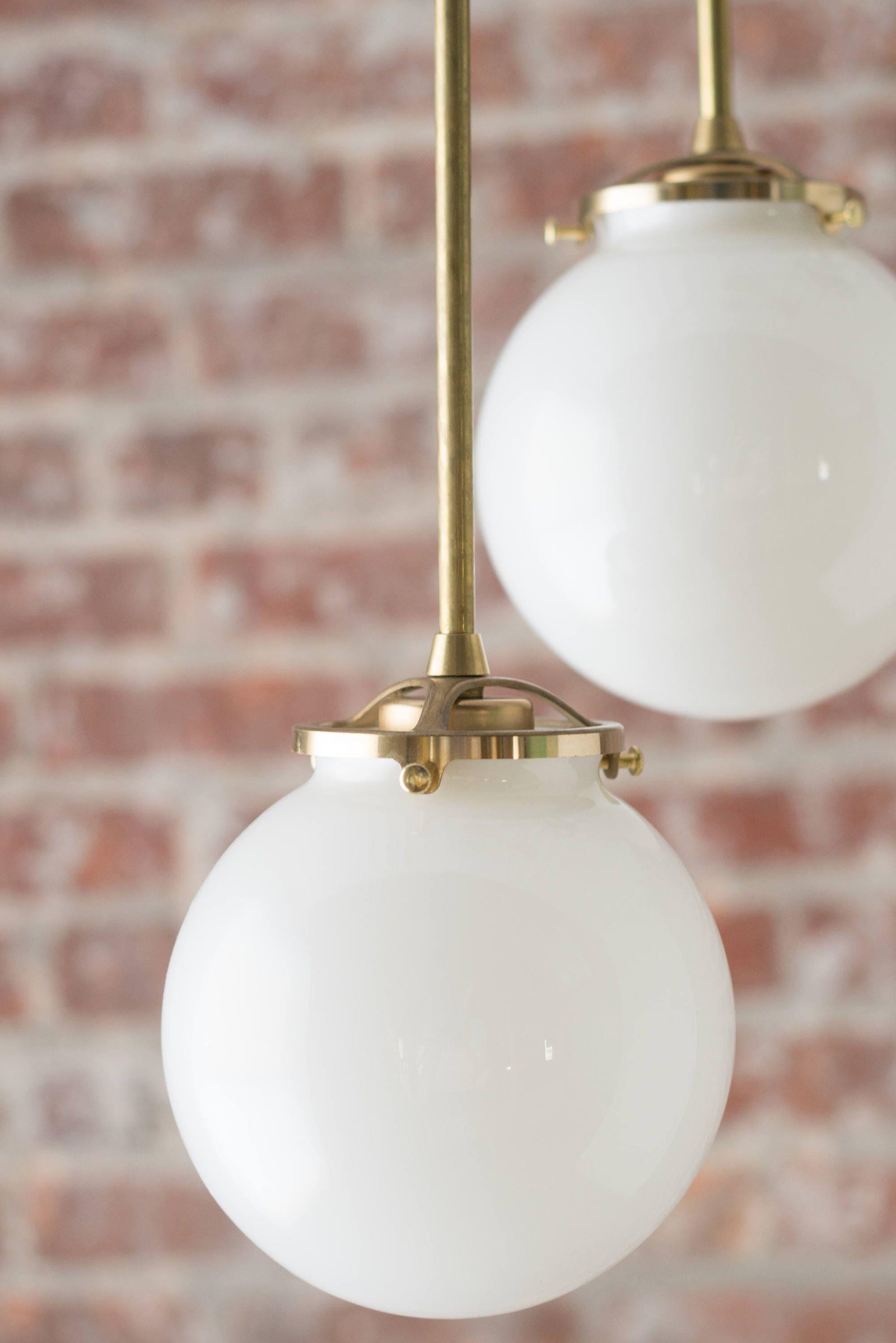 Mid-century modern chandelier with raw brass finish and two white glass globe shades suspended on rods. - CHANDELIER MODEL NO. 1809