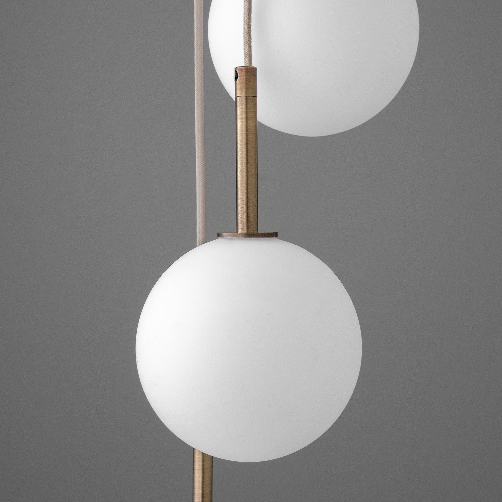 Minimalist chandelier with two frosted white glass globes and antique brass fixtures on tan cords. - CHANDELIER MODEL NO. 4701