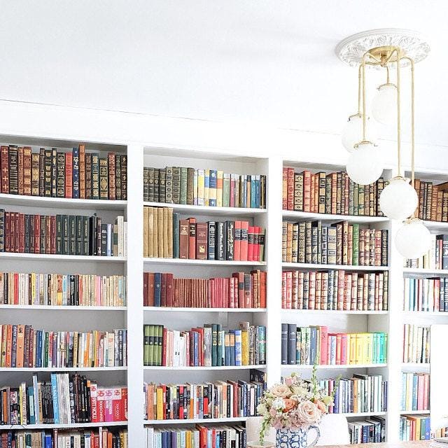 Mid-century modern chandelier with raw brass finish and five white glass globe shades hanging in a bright library room. - CHANDELIER MODEL NO. 1809