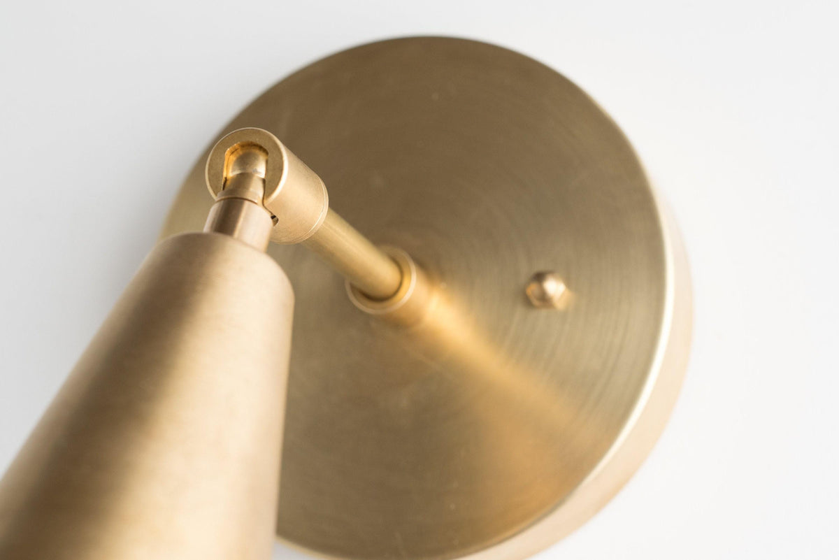 Raw brass adjustable wall sconce with cone-shaped shade and round backplate. - SCONCE MODEL NO. 4339