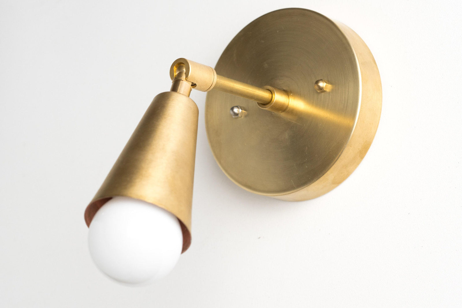Mid-century modern raw brass wall sconce with adjustable arm and exposed bulb. - SCONCE MODEL NO. 4339