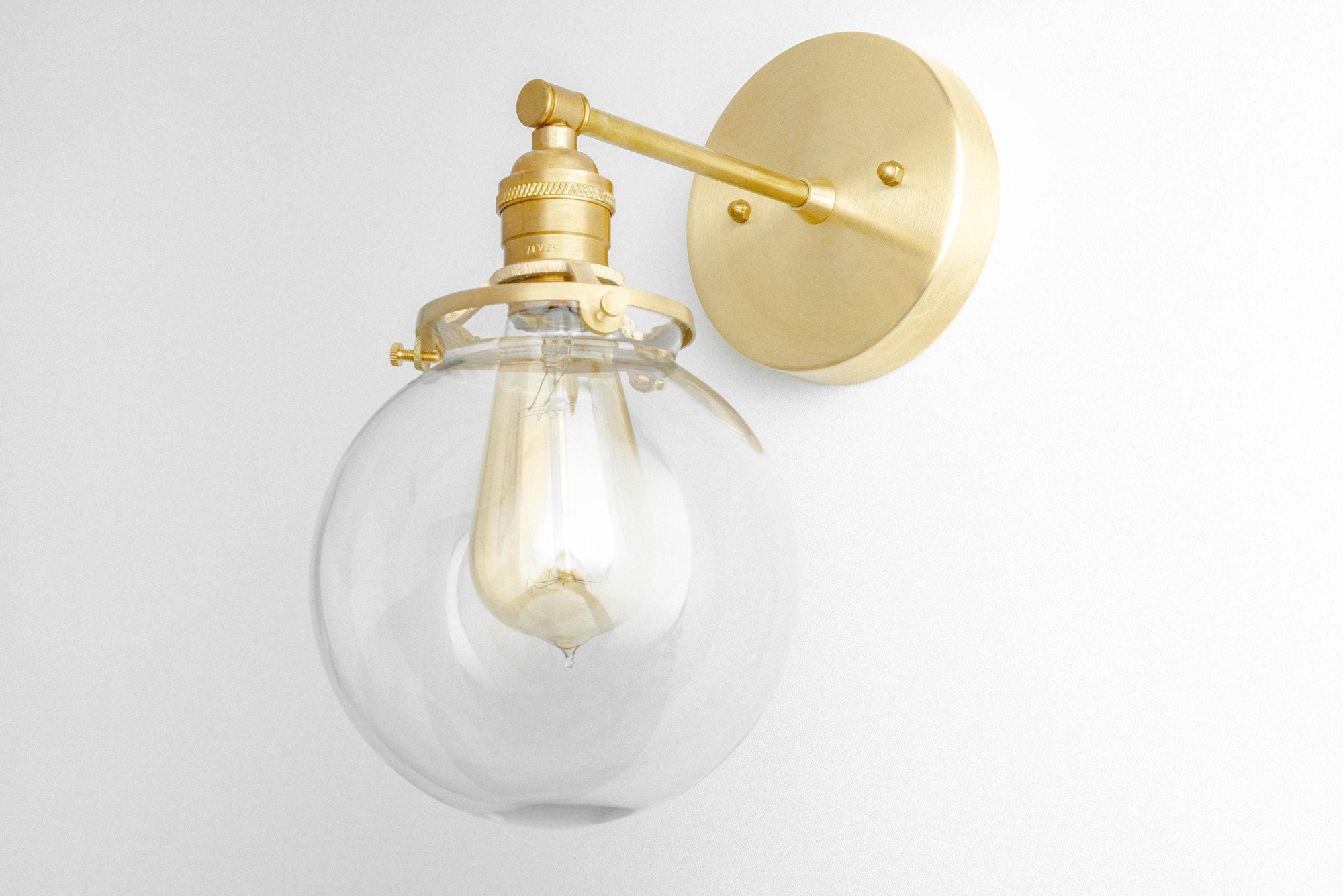 Mid-century modern wall sconce with clear globe glass and raw brass fixture. - SCONCE MODEL NO. 5456