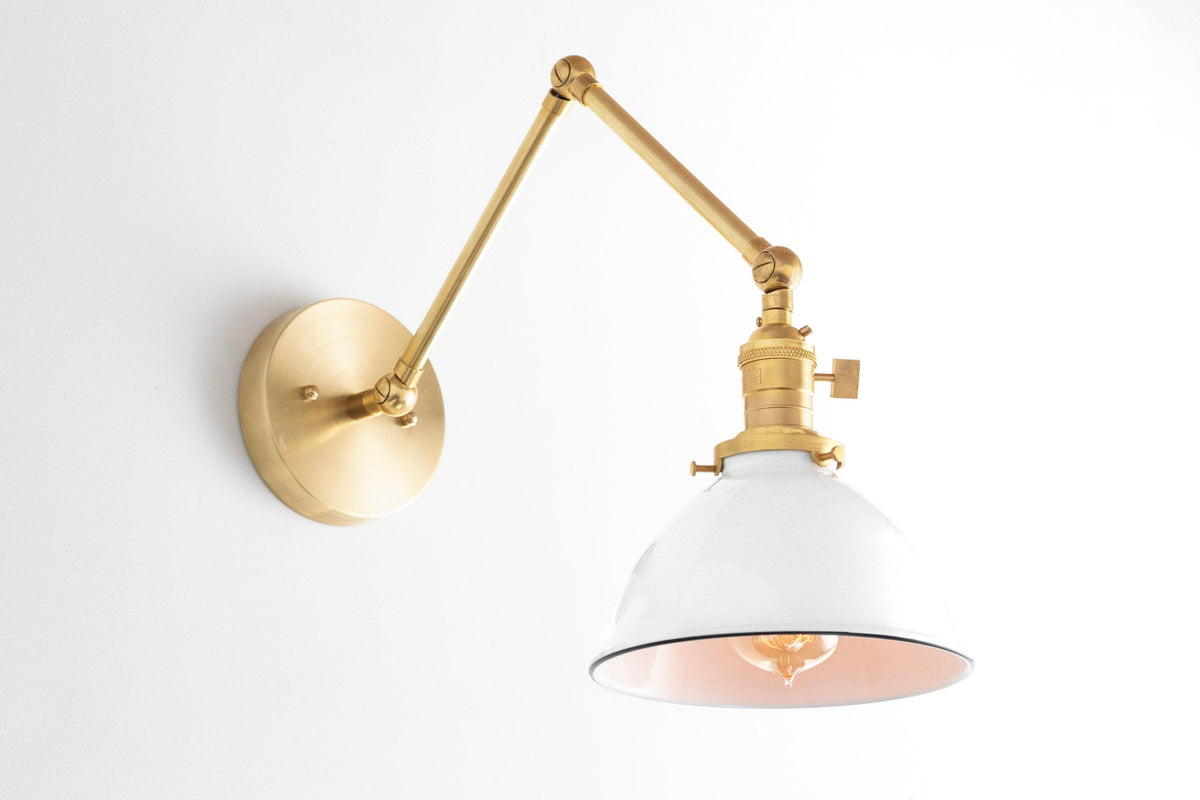 Adjustable wall sconce with raw brass arm and white metal shade with copper interior. - SCONCE MODEL NO. 8551