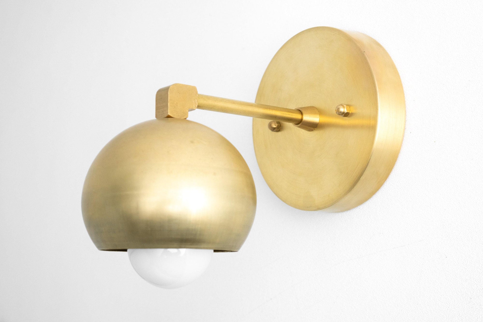 Mid-century modern raw brass wall sconce with dome shade and round backplate. - SCONCE MODEL NO. 0053