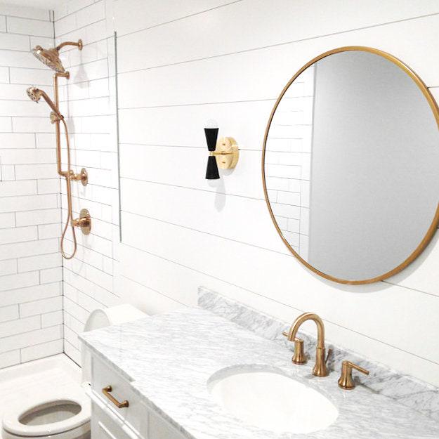Mid-century modern bare bulb sconce with black shades and brass base mounted on white shiplap wall above marble vanity. - SCONCE MODEL NO. 4717