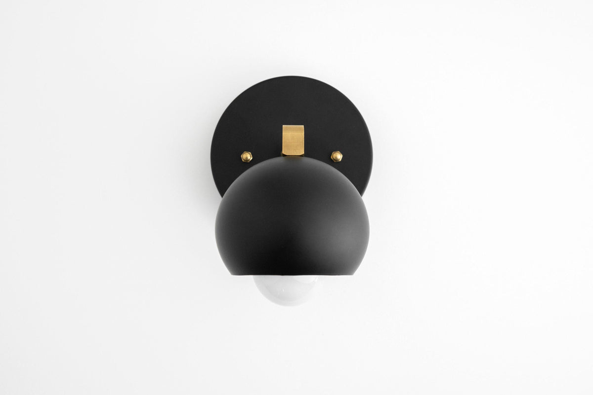 Mid-century modern black metal wall sconce with matte black dome-shaped shade and brass accent plate. - SCONCE MODEL NO. 0053