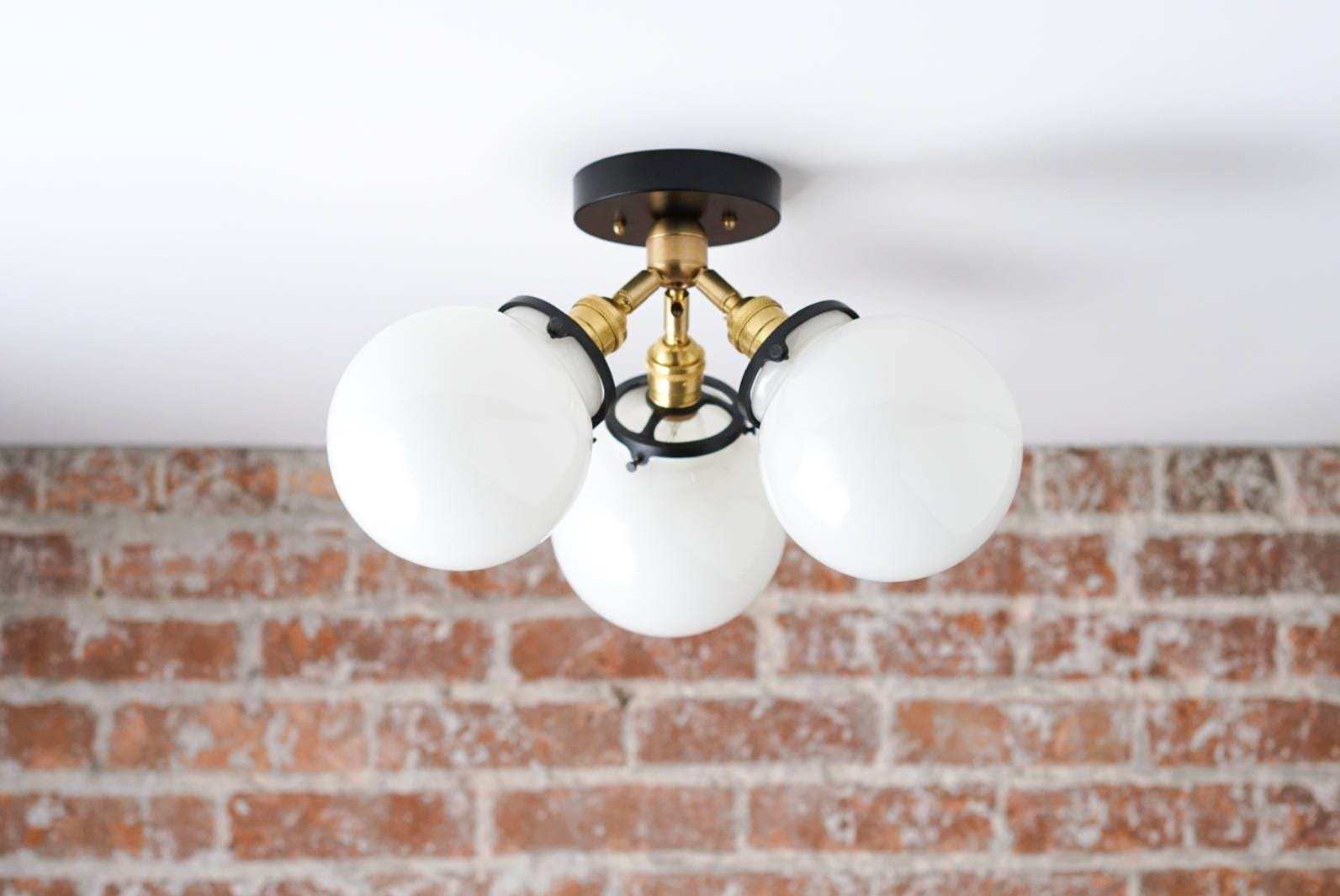 Flush mount ceiling light with three white glass globes and black and brass fixture details. - CEILING LIGHT MODEL NO. 0210