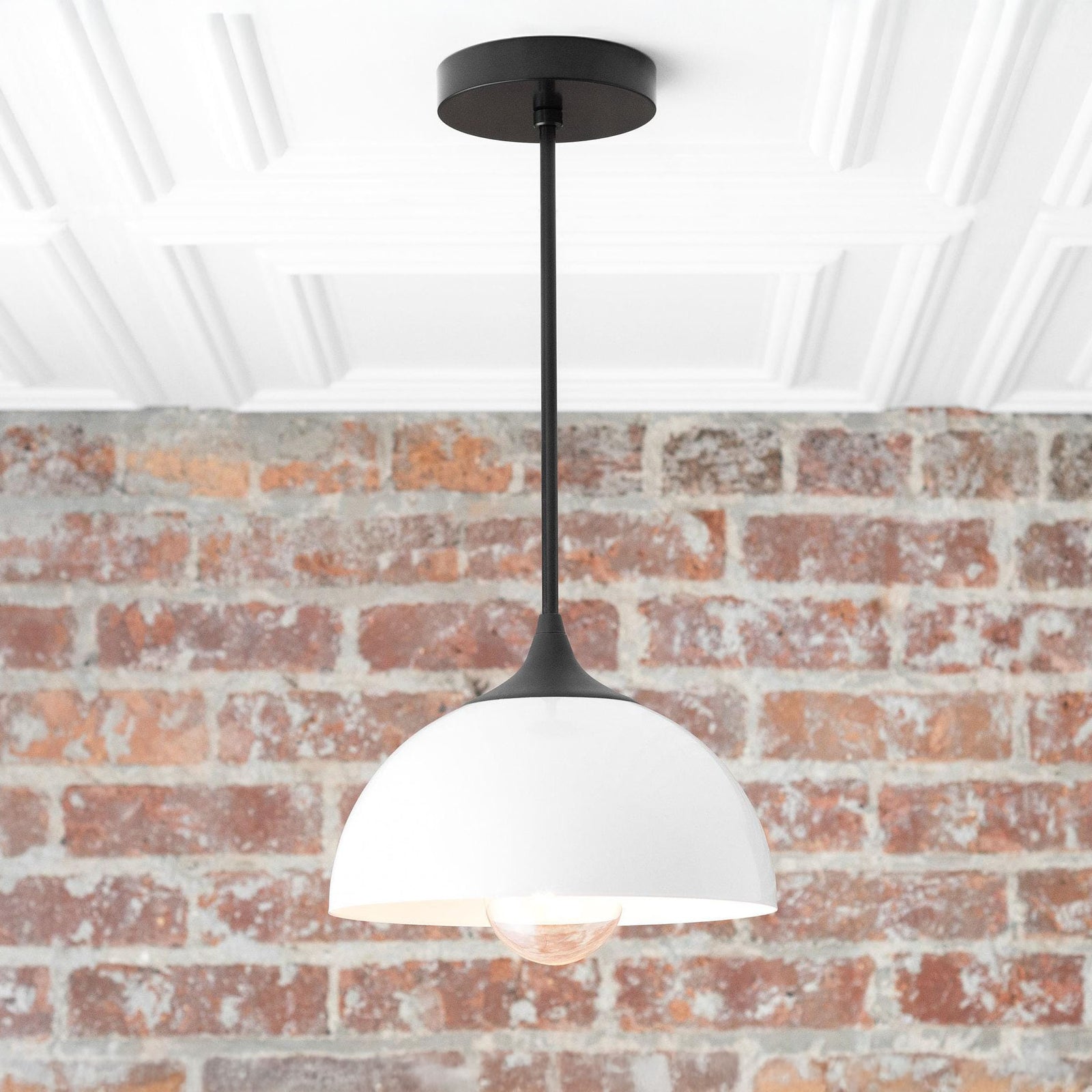 Mid-century modern black and white pendant lamp with dome-shaped shade and exposed bulb against brick wall. - PENDANT MODEL NO. 9263
