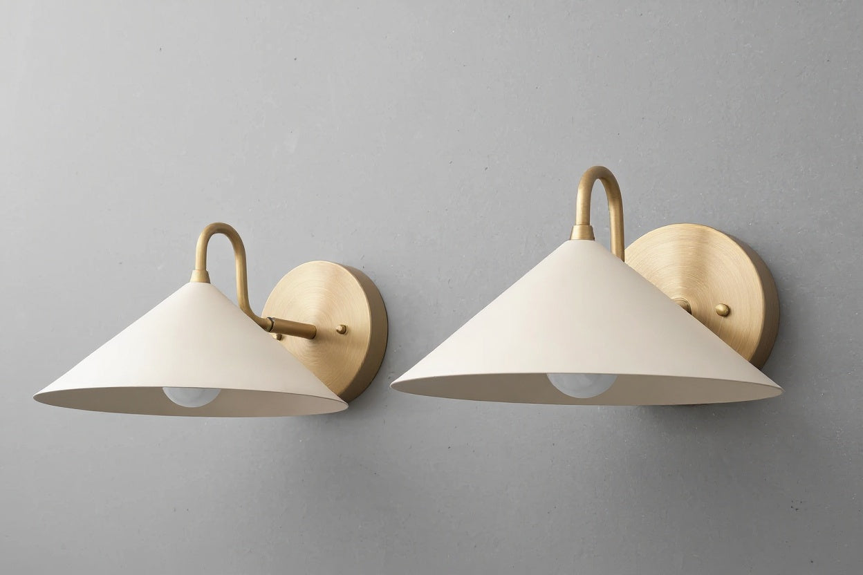Pair of antique brass wall sconces with cream conical metal shades and round backplates. - SCONCE MODEL NO. 6528