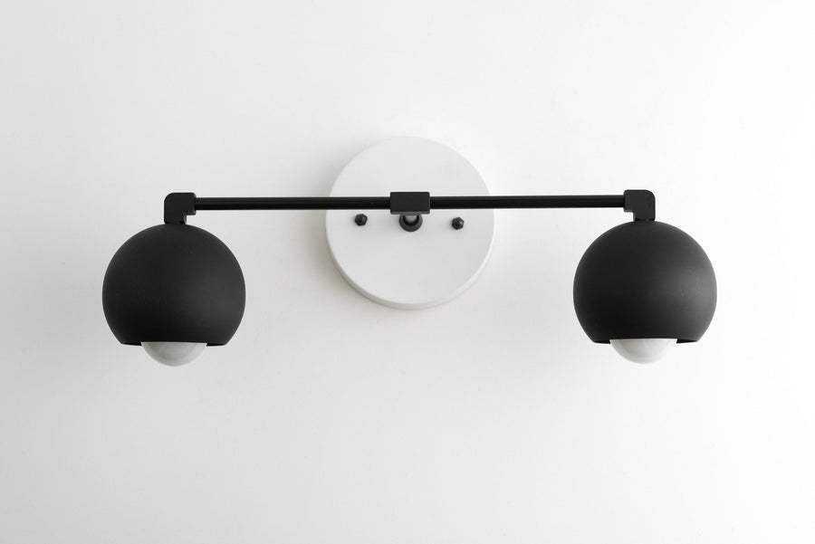 Mid-century modern black metal vanity light with two spherical shades and white circular wall mount. - VANITY LIGHT MODEL NO. 5469