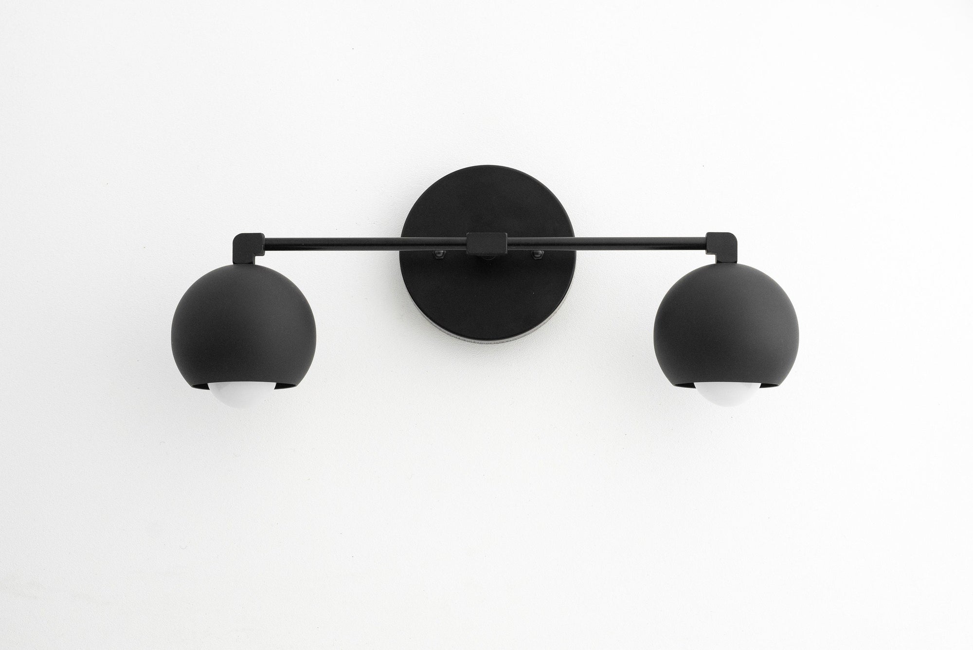 Mid-century modern black metal vanity light with two round shades and matte finish. - VANITY LIGHT MODEL NO. 5469