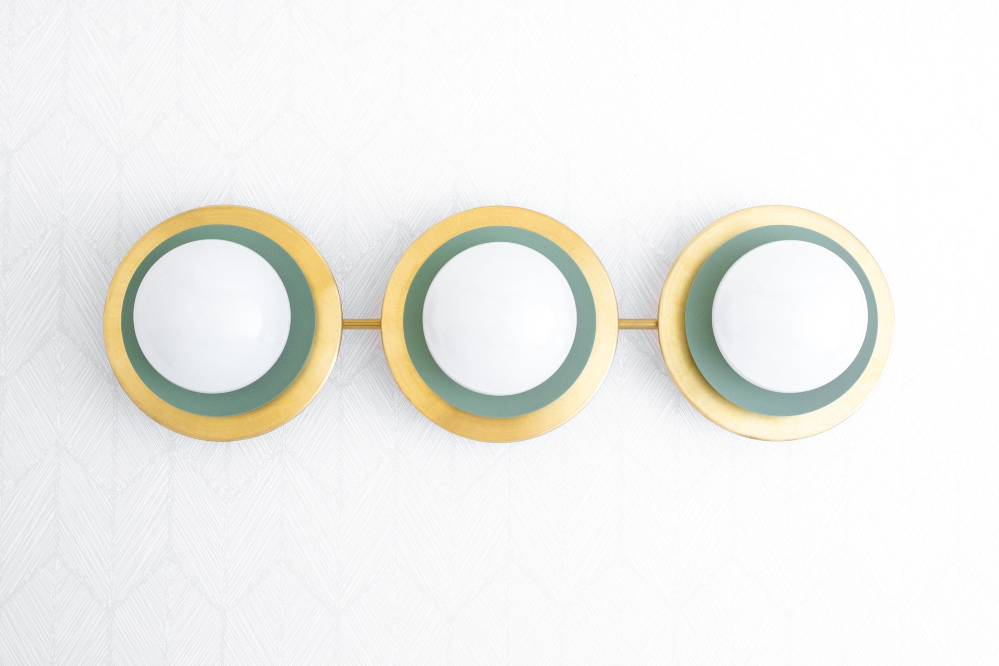 Raw brass vanity light with three white globe bulbs and green circular accents. - VANITY LIGHT MODEL NO. 7680